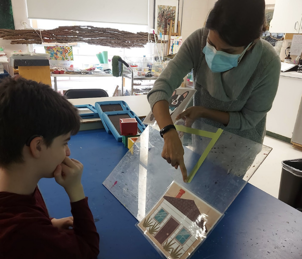 A woman working with a child to complete the mission of helping a lost dog return home using lines.
