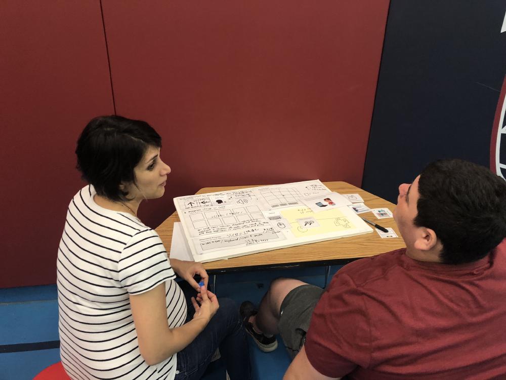 Facilitator and camp participant brainstorming design ideas for program interface.