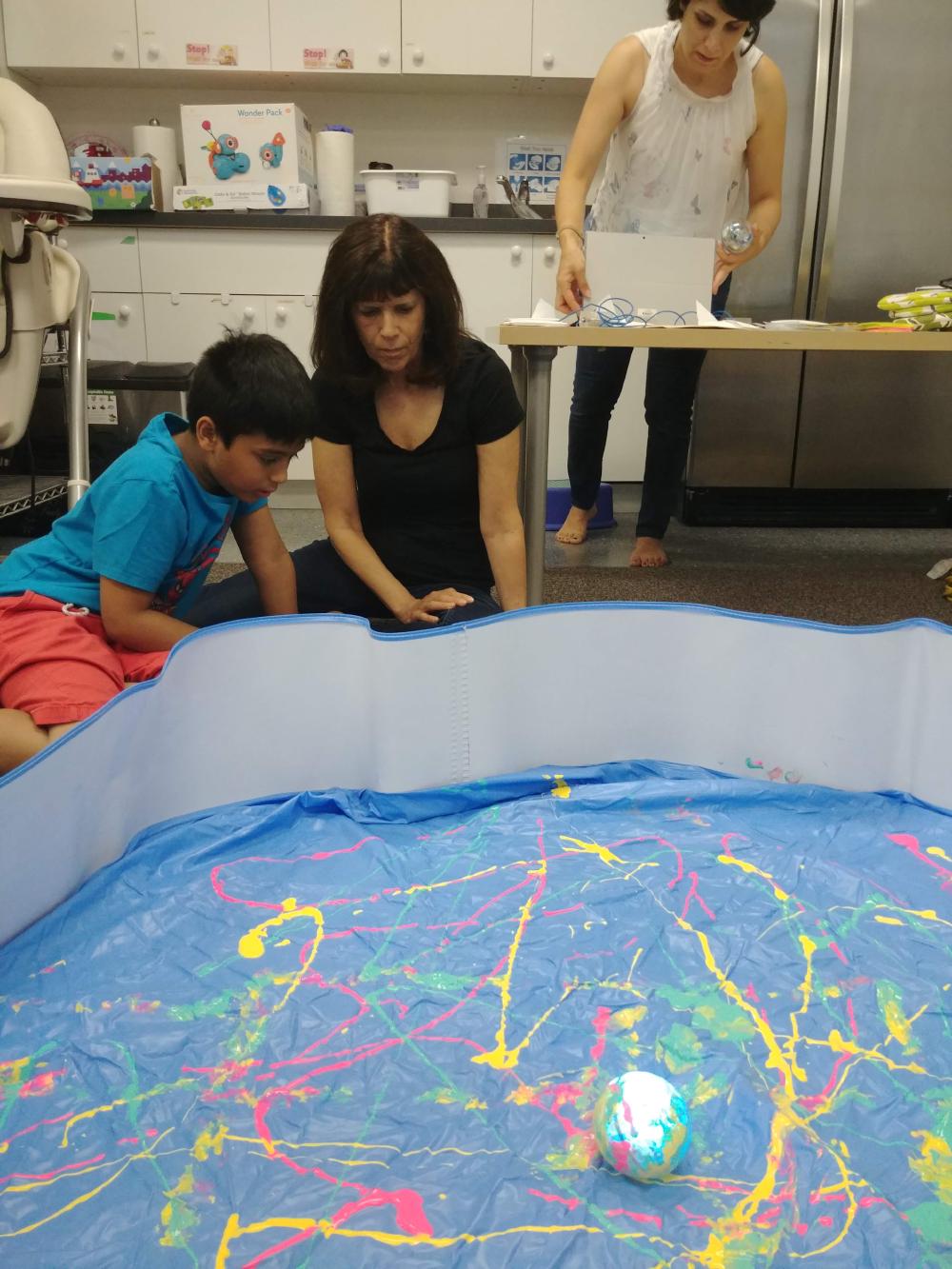 A camper codes a sequence with the C2LC prototype that a Sphero robot does in paint in front of him.