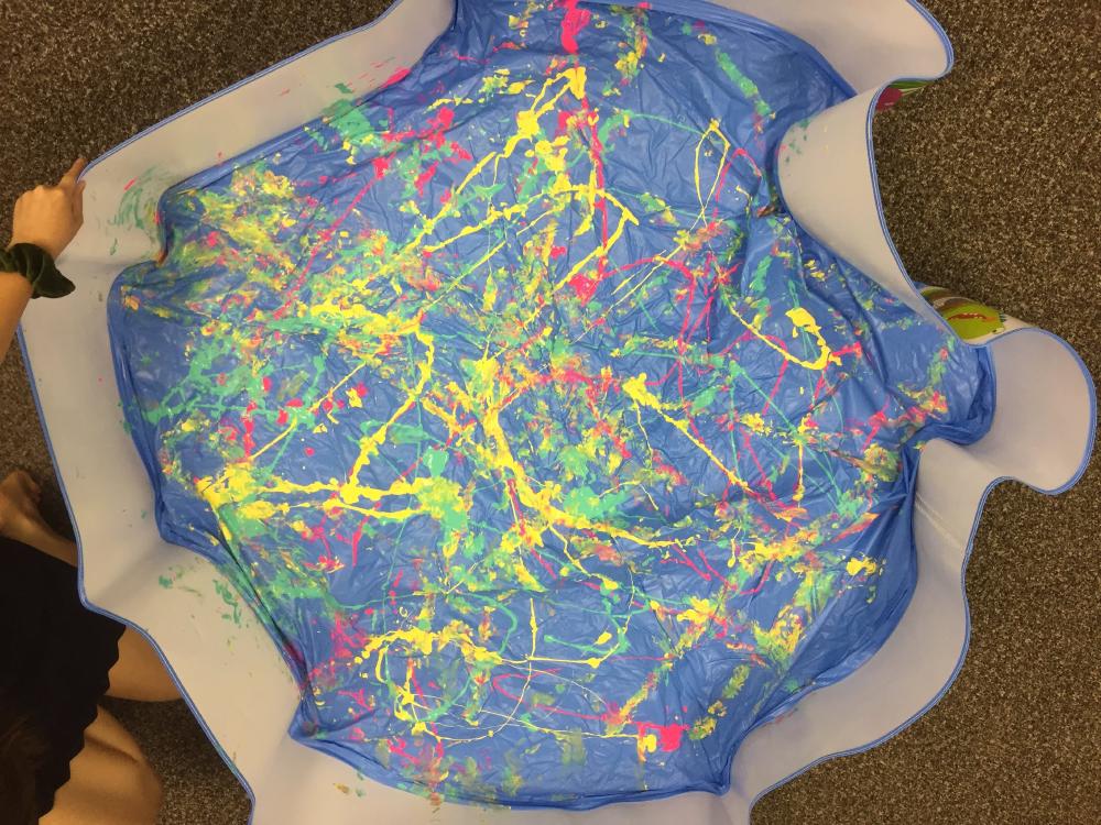 Paint pattern made in a kiddie pool from robots rolling around in paint.