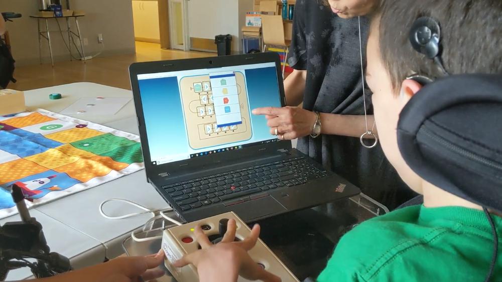 Student using clicker to plan sequence for Cubetto